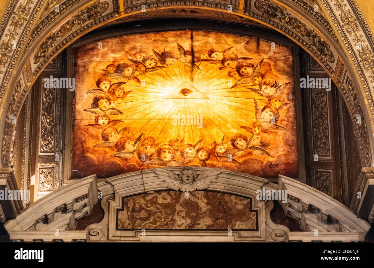 Medieval fresco decorating wall under an arch inside catholic cathedral in Rome, representing the shining eye of god surrounded by a group of angels Stock Photo