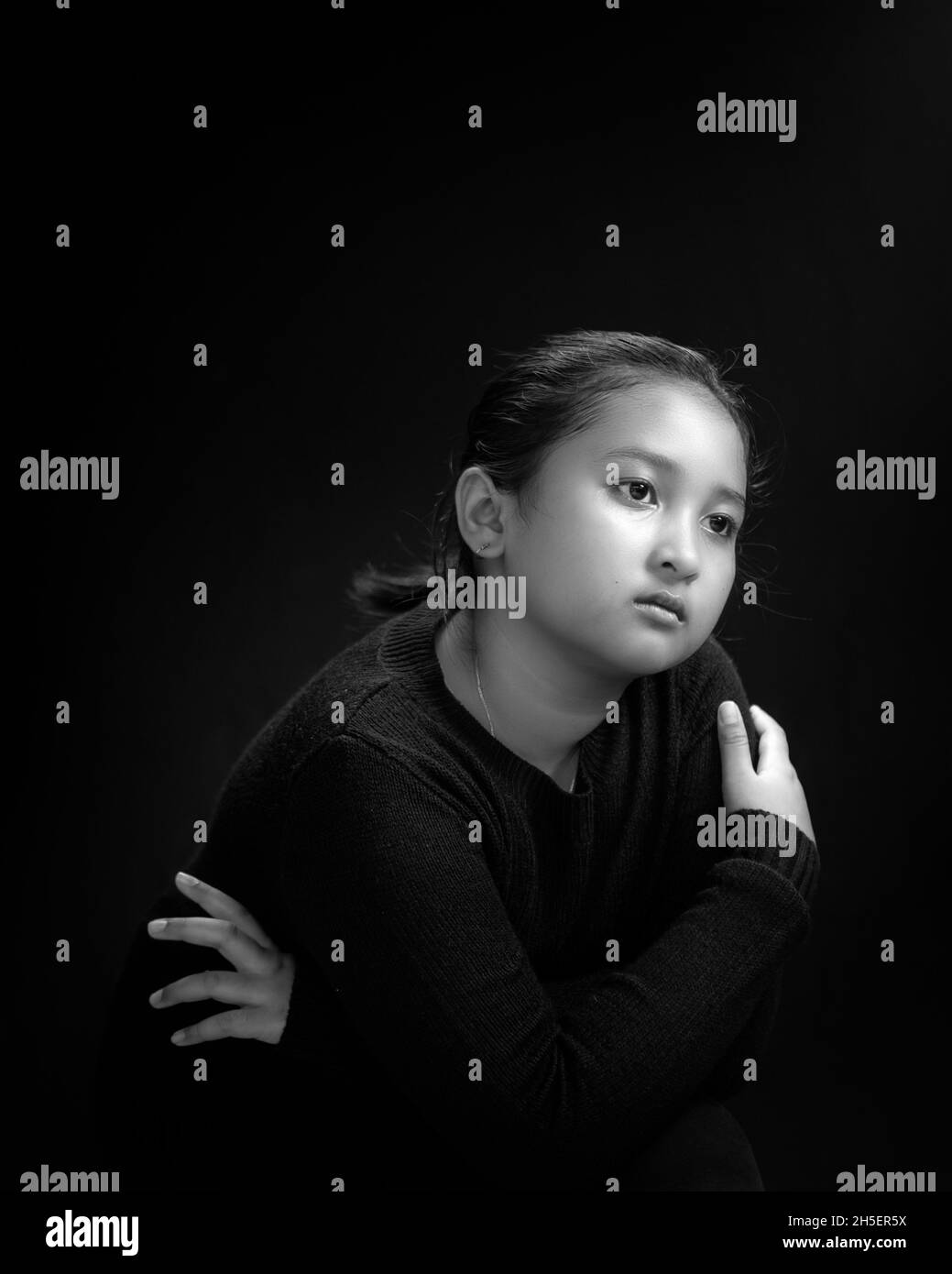 Girl wearing black shirt and black background in Black & White portrait Stock Photo