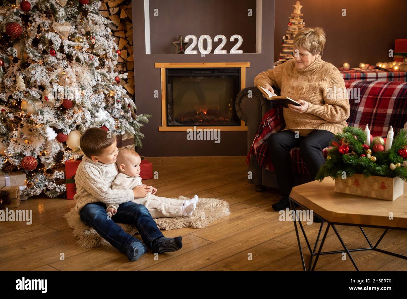 Readings For Christmas Eve 2022 Grandmother Reading Book To Grandchildren Near Christmas Tree At Home,  Happy New Year 2021 Stock Photo - Alamy