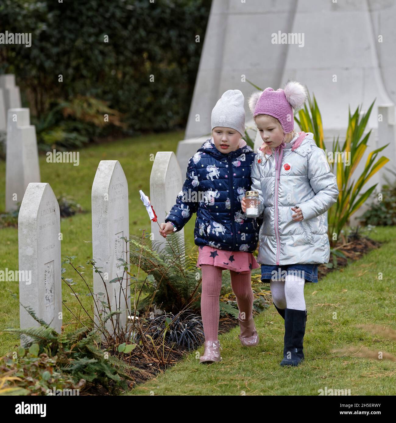 Sunday 7th November 2021. Brookwood Military Cemetery. The local Polish Community gather to remember the fallen and pay their respects. Children place candles & the national colours at headstones in the Polish plot. Stock Photo