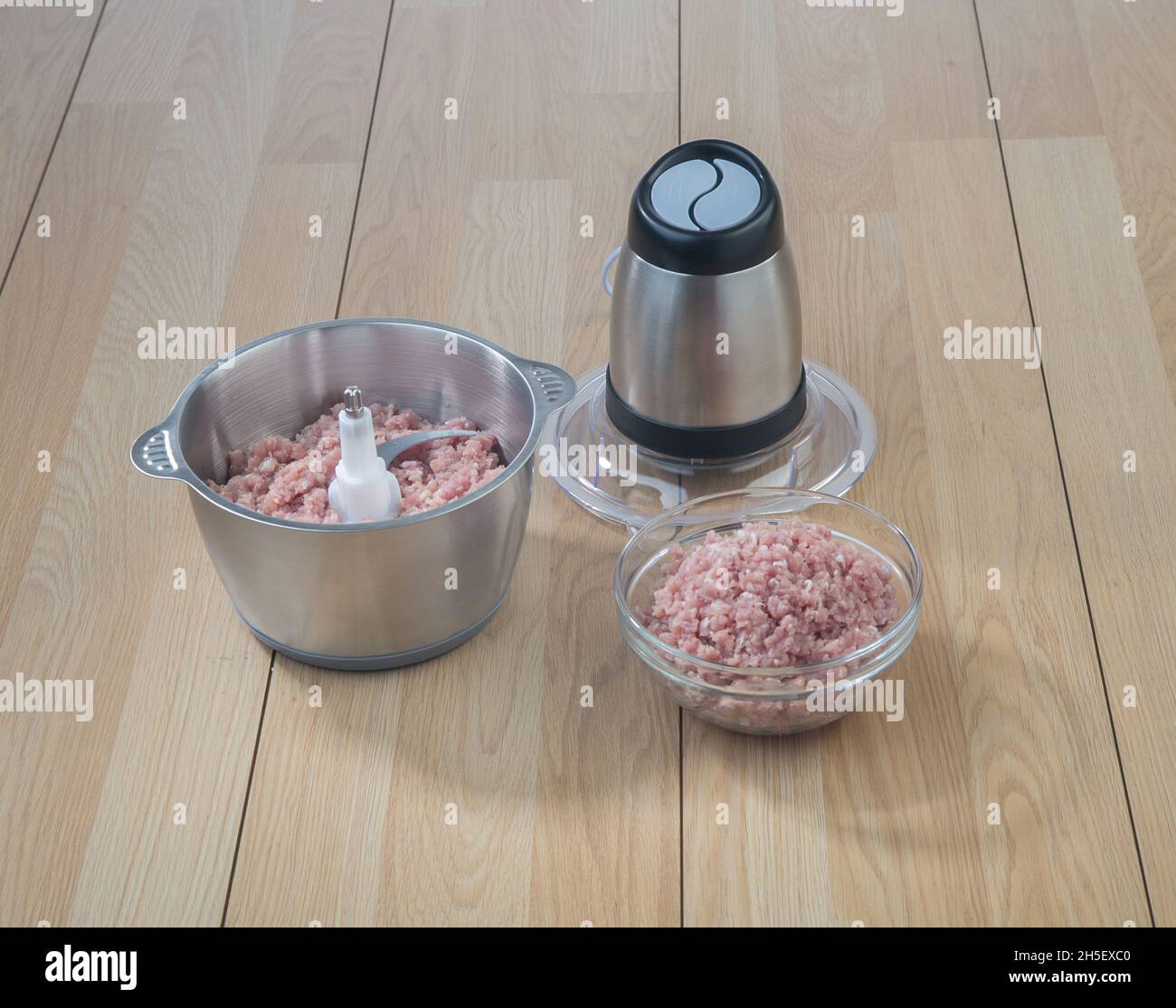 Food processor with mince pork on wooden table background Stock Photo