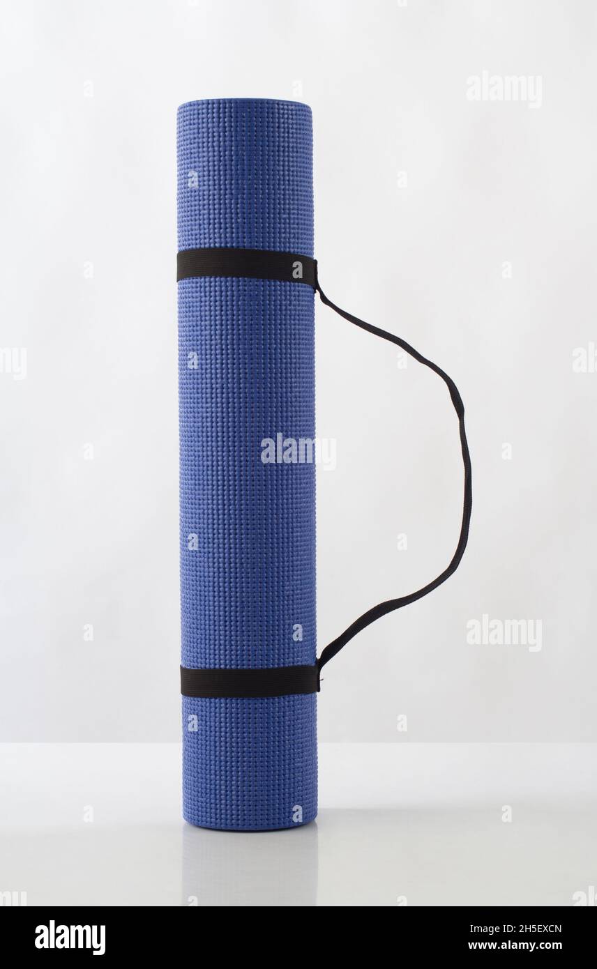Rolled up blue yoga mat isolated on white background Stock Photo