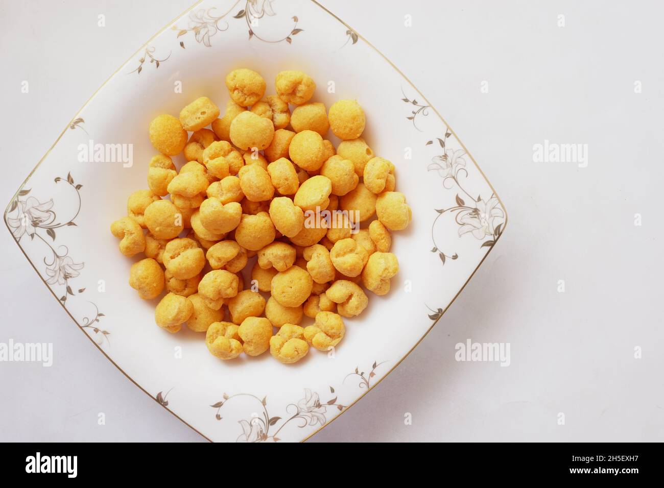 puffed corn rings chips in black bowl on white background Stock Photo Alamy