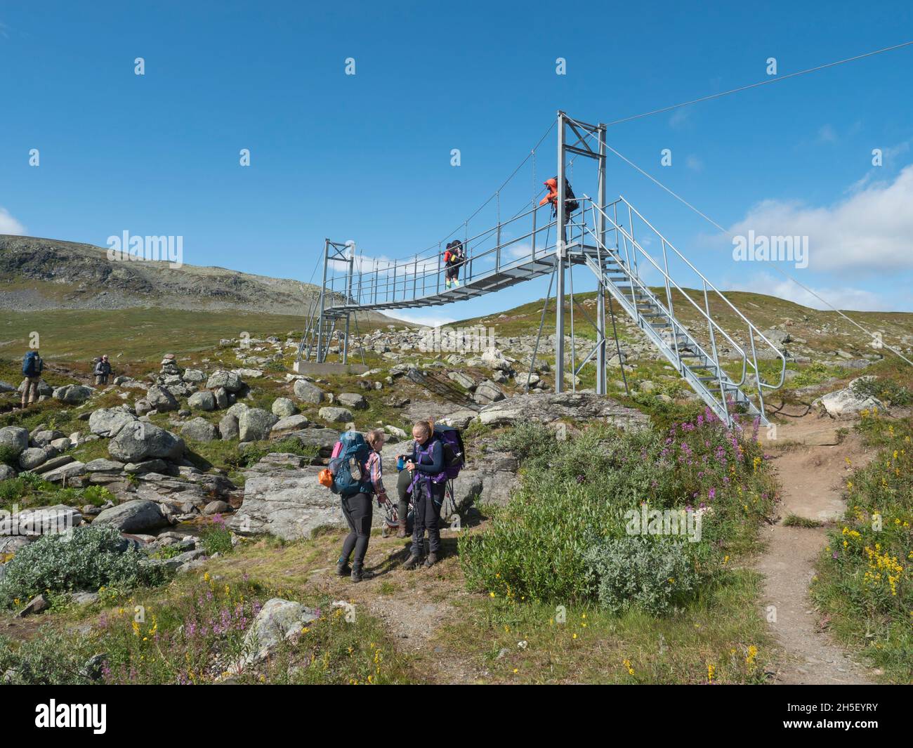 Sweden, Jokkmokk, Norrbotten, 4 August, 2021 Hikers crossing iron