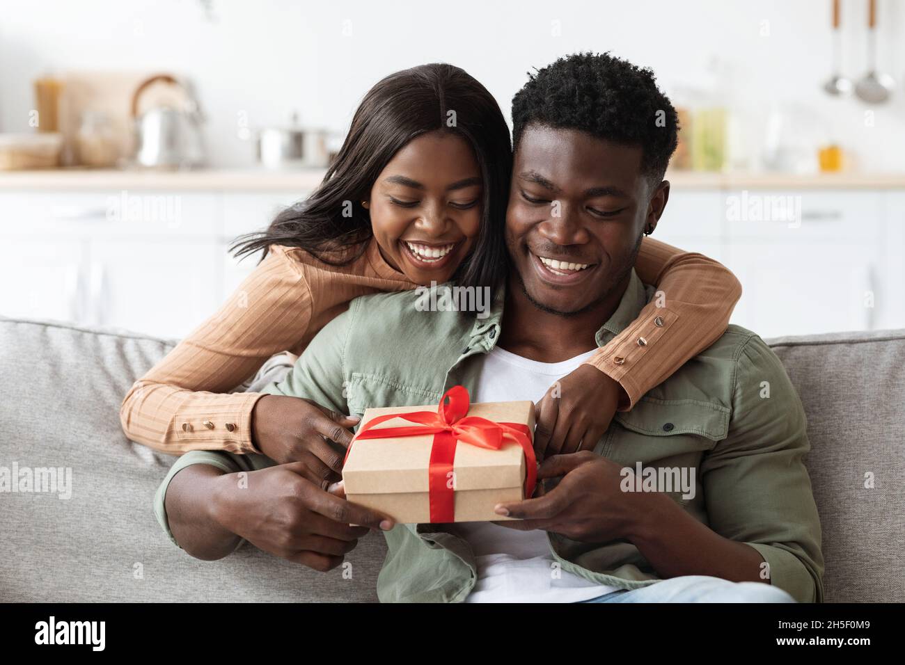 Emotional african american lady hugging her lover, giving present Stock ...