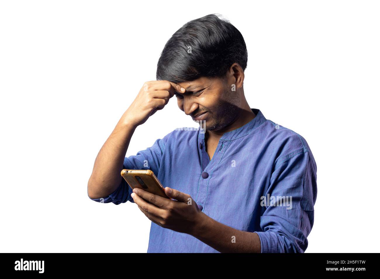 A young Indian male in blue dress facing headache with smart phone in hand  on white background Stock Photo - Alamy