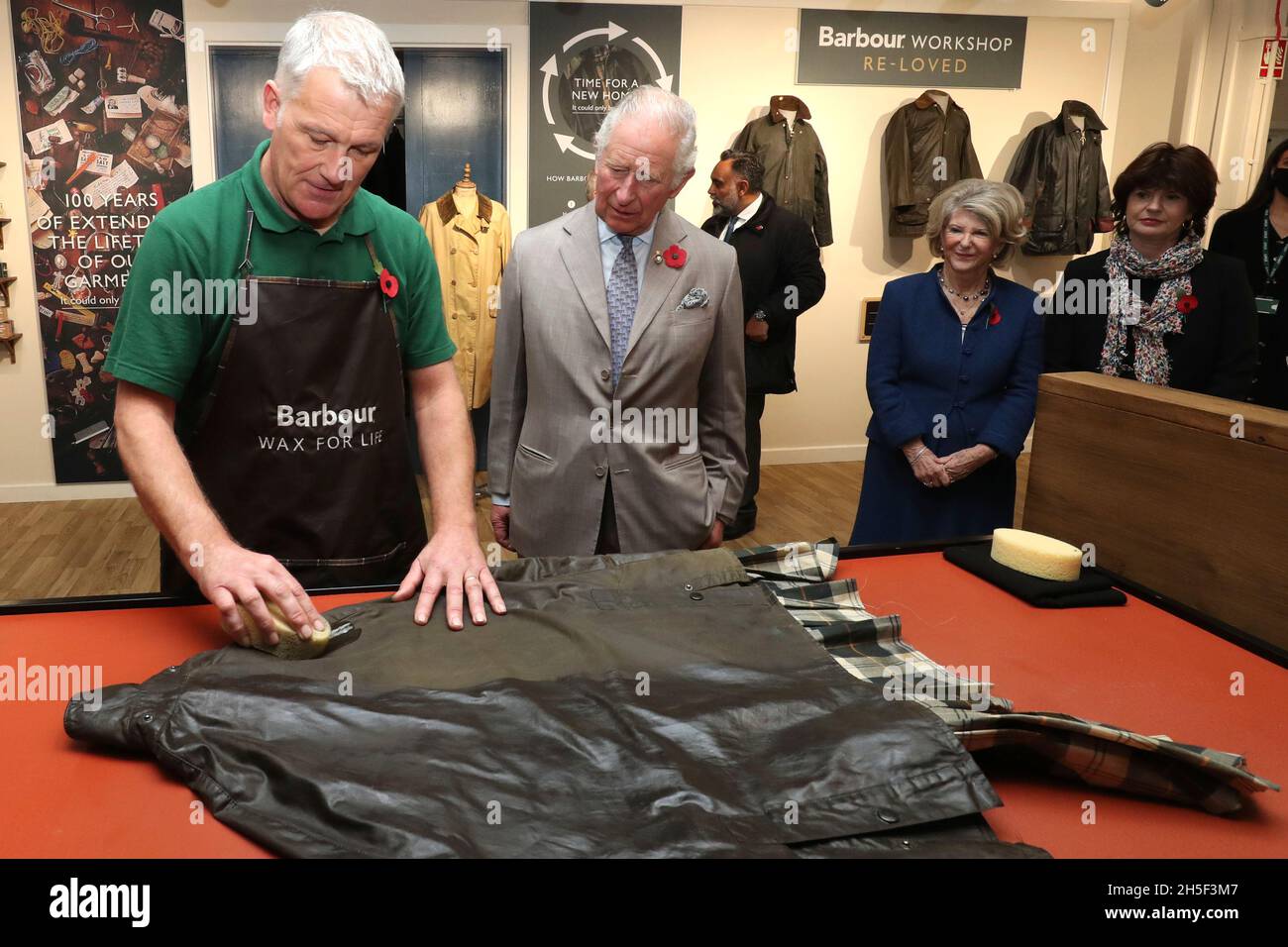 The Prince of Wales watches as Neil Travis (left) demonstrates how to  reproof a wax jacket during his tour of J Barbour And Sons Ltd in South  Shields, to mark 100 years