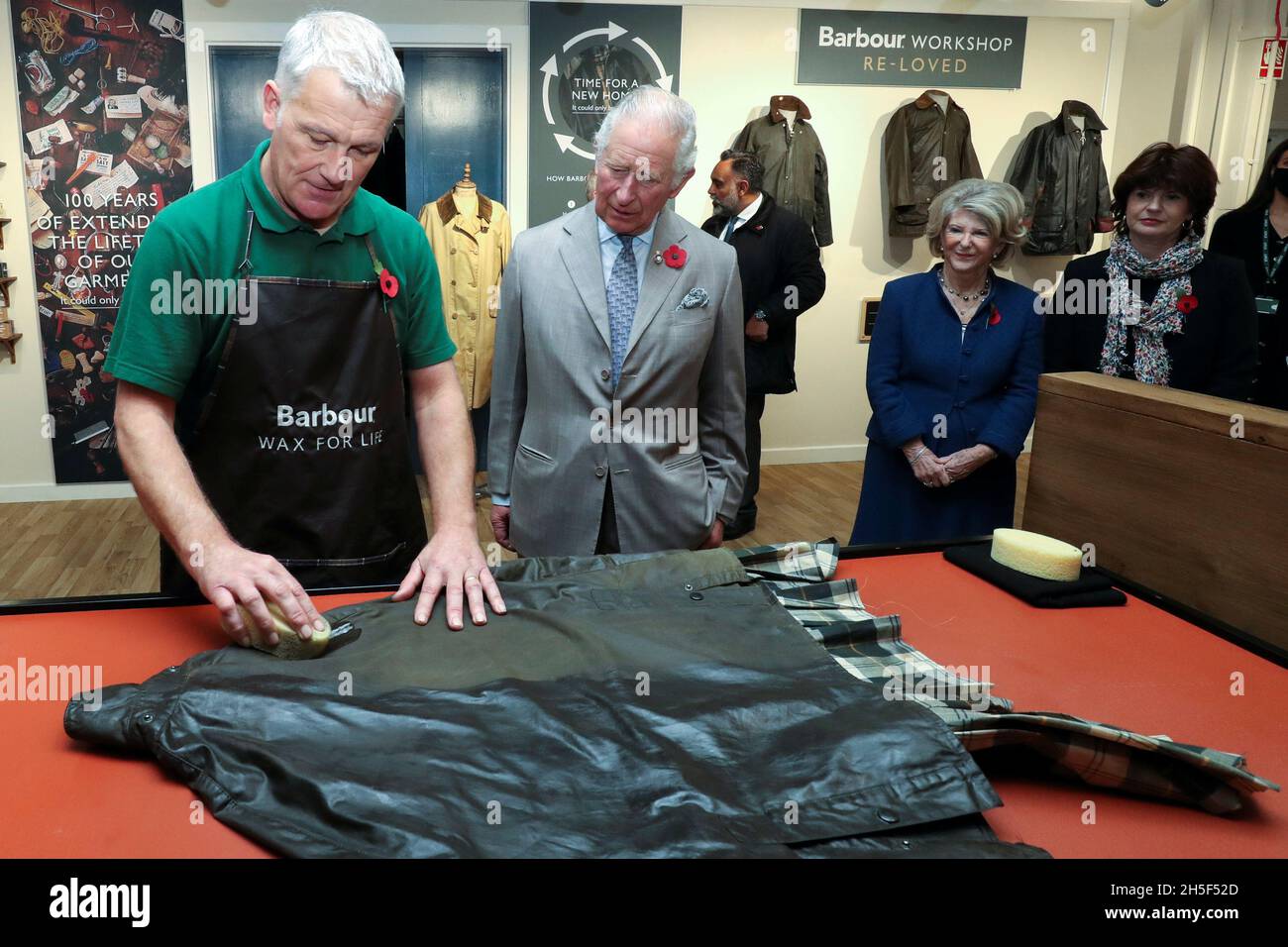 Britain's Prince Charles looks on as Neil Travis, a reproofer of wax  jackets, demonstrates during a visit to Royal Warrant Holder, J Barbour And  Sons Ltd, in South Shields, Britain November 9,