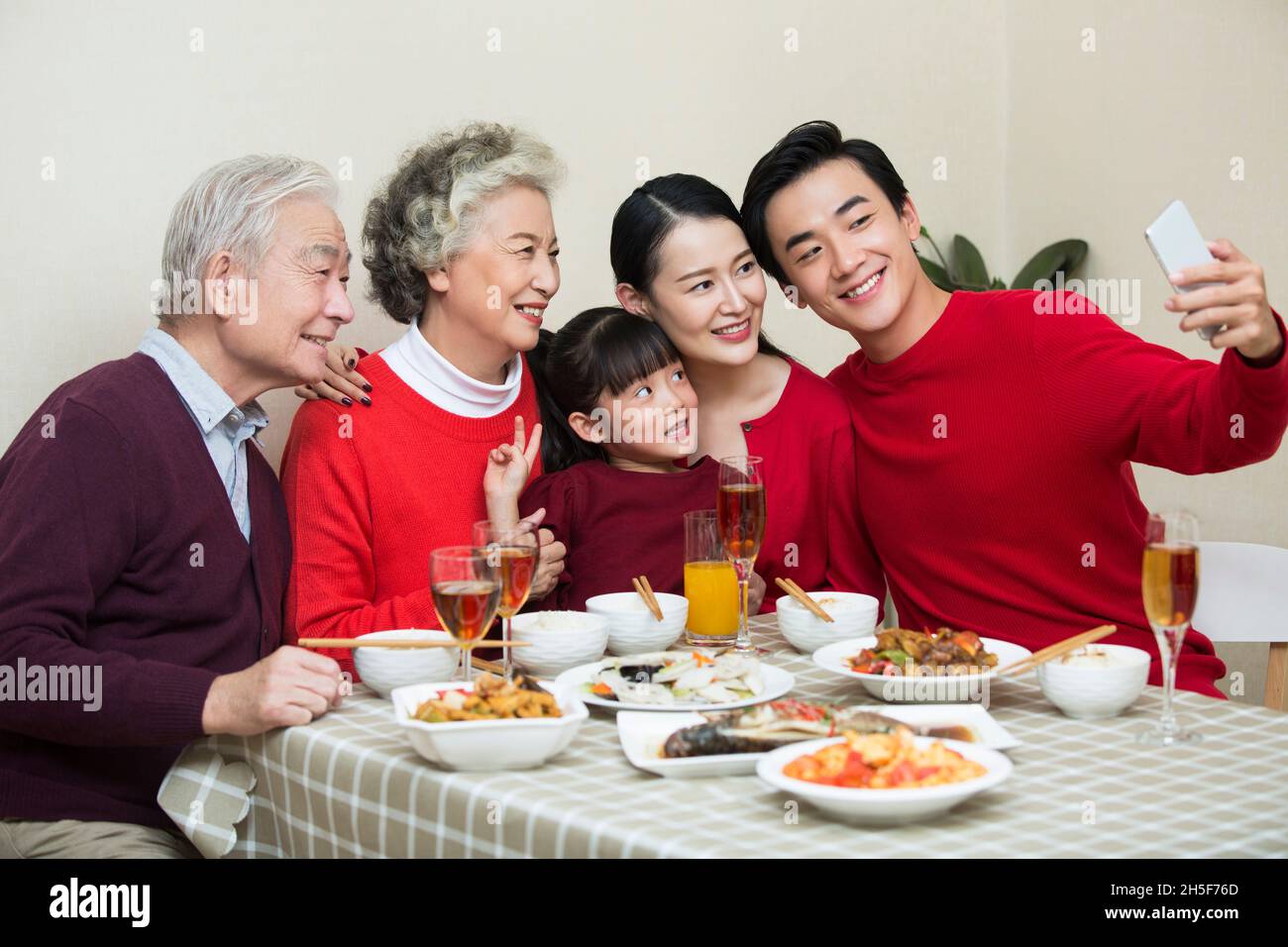 Happy family taking photos together over the New Year's reunion dinner Stock Photo