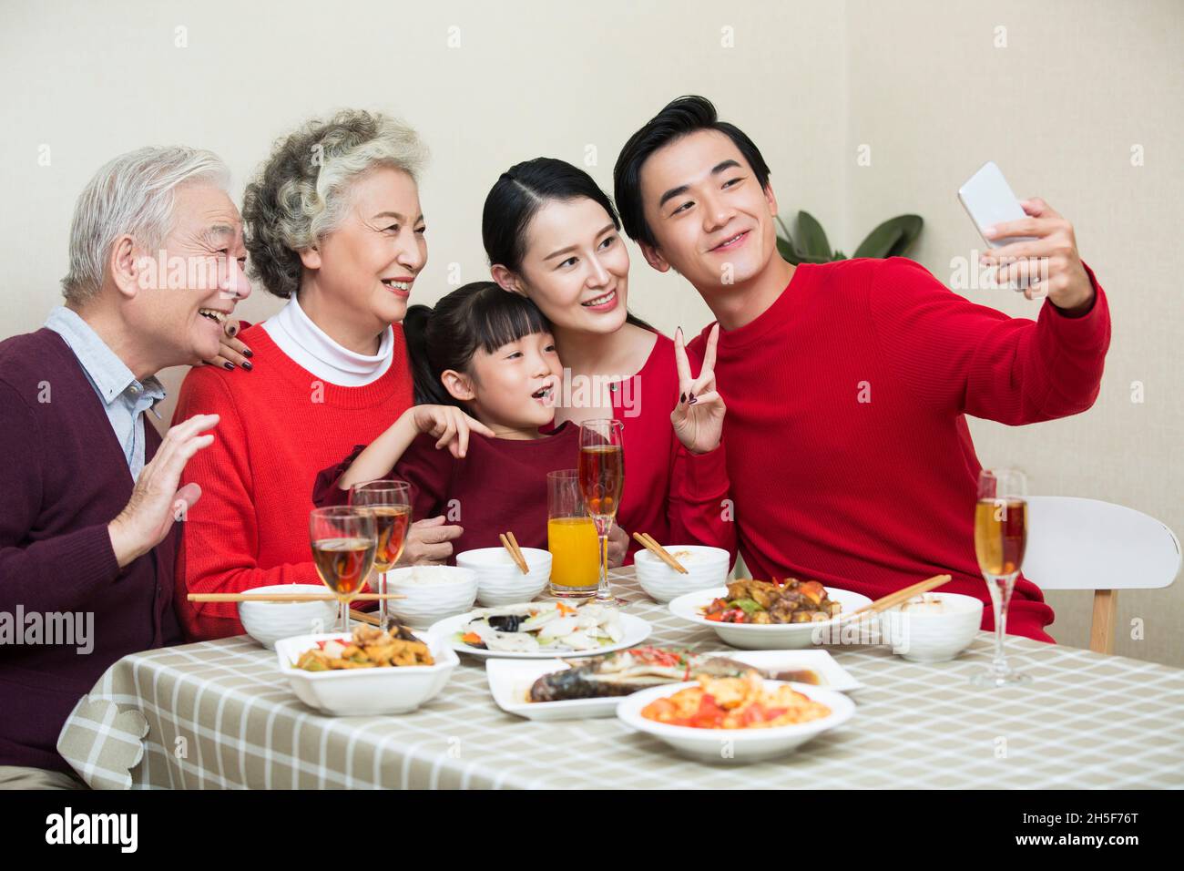 Happy family taking photos together over the New Year's reunion dinner Stock Photo