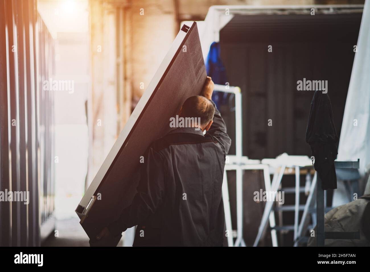 The worker is carrying a large table cover Stock Photo