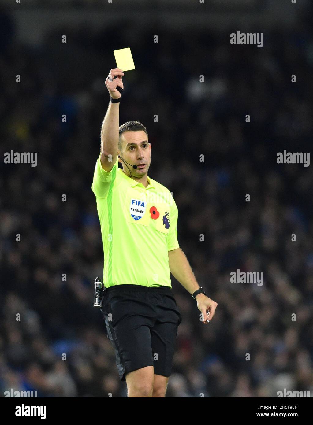 Referee David Coote holds up a yellow card during the Premier League match between Brighton & Hove Albion  and Newcastle United at The Amex Stadium  , Brighton  , UK - 6th November 2021   Editorial use only. No merchandising. For Football images FA and Premier League restrictions apply inc. no internet/mobile usage without FAPL license - for details contact Football Dataco Stock Photo
