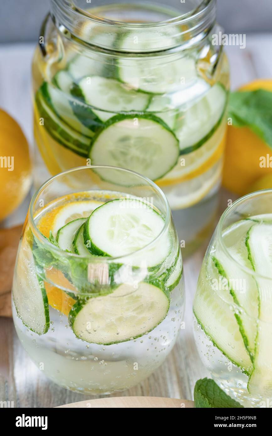 Detox refreshing sassy water with cucumber, ginger, mint and lemon in glasses, Healthy eating concept. Light background. Close-up. Body detoxication. Stock Photo