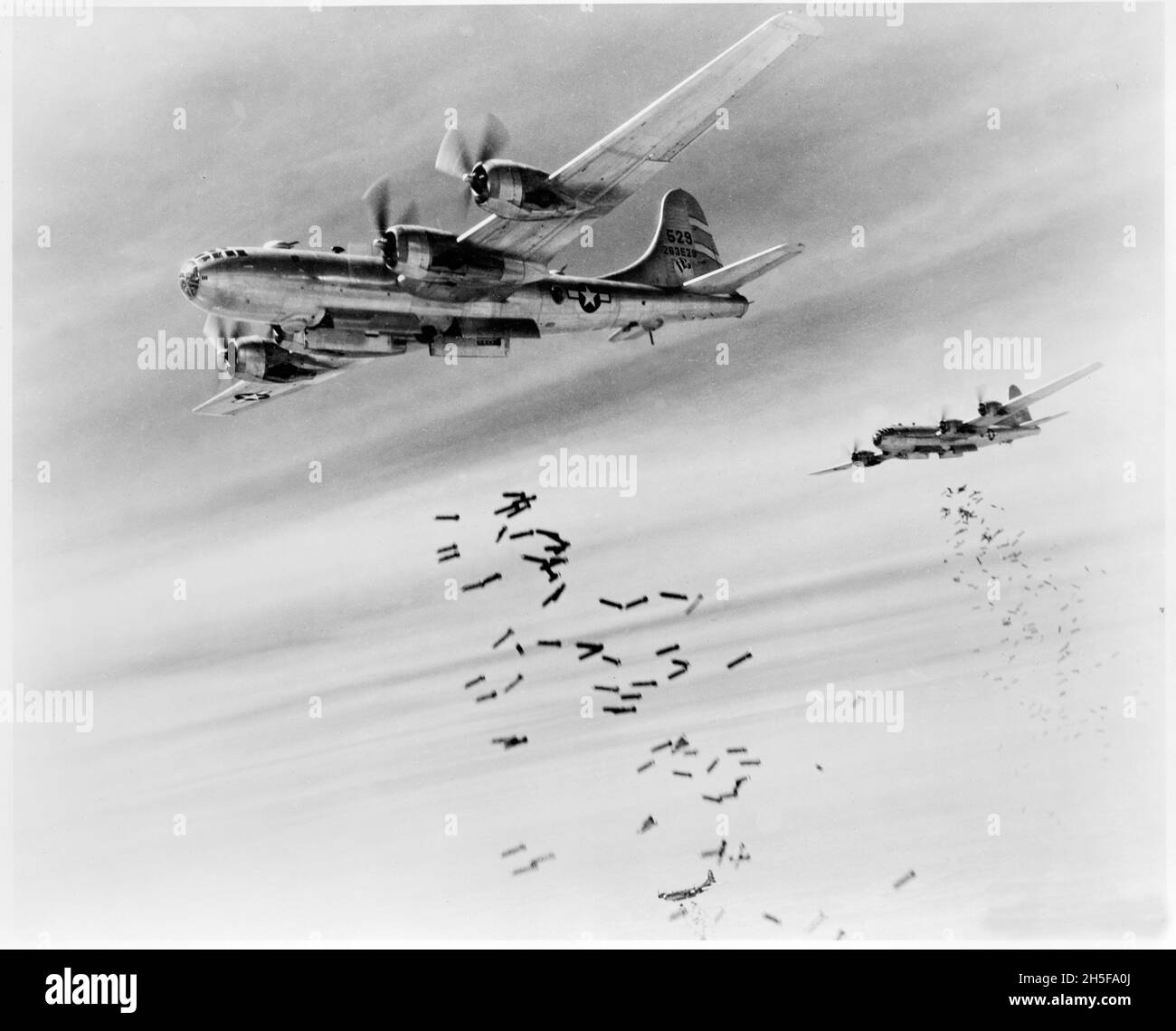 Vintage photo circa 1945 of a pair of Boeing B29 Superfortress bombers of the United States air force XX Bomber Command dropping bombs over Japan Stock Photo