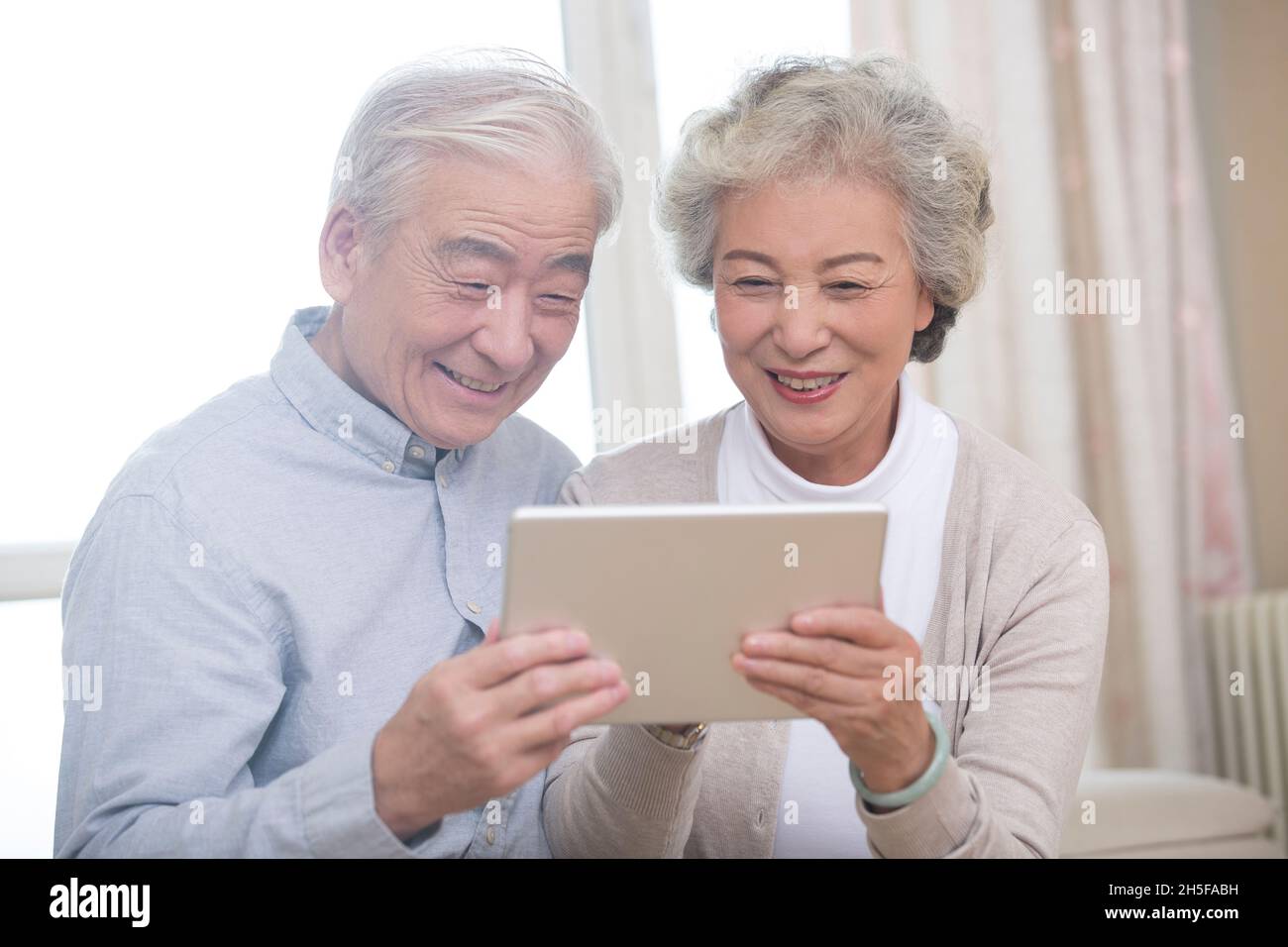 Happy elderly couples using tablets Stock Photo