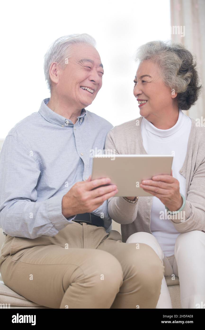 Happy elderly couples using tablets Stock Photo