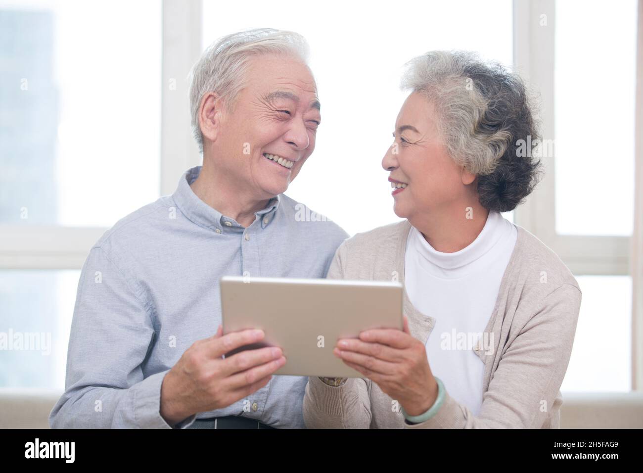 Happy elderly couples using tablets Stock Photo
