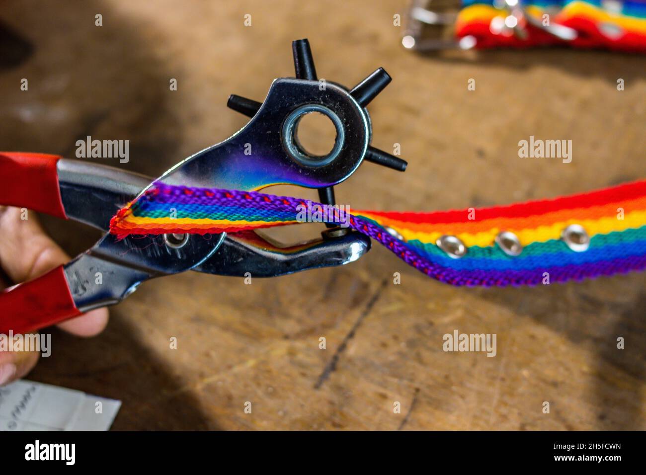 Closeup shot of a colorful pet collar being fixed in a workshop Stock Photo