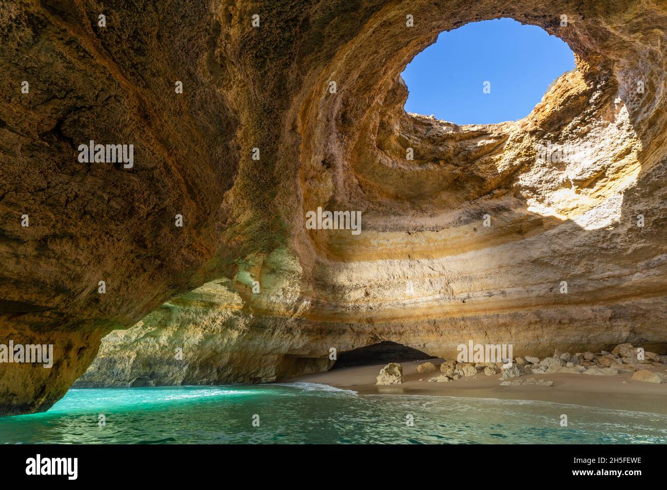 The seacave of Benagil is a well known tourist destination. The seacave has a hole in the roof and is accessed by boat. It is located in the Algarve r. Stock Photo