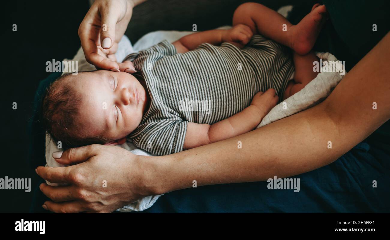 Closeup portrait of mother's hands holding her new born baby in her