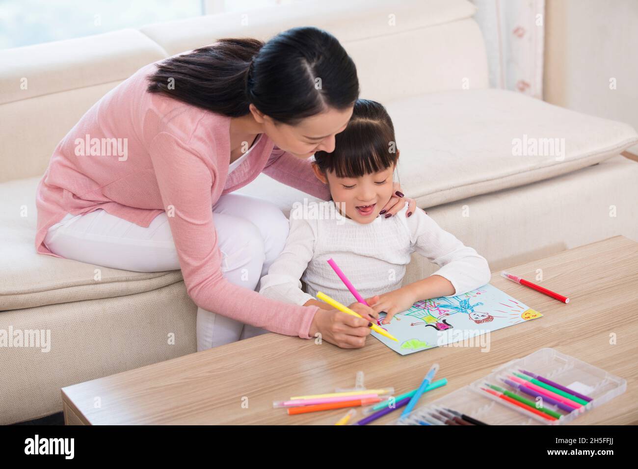 Mother and daughter drawing pictures together Stock Photo
