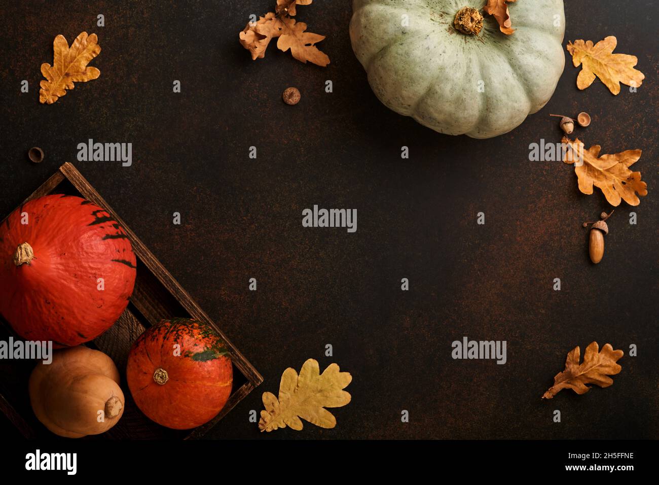 Pumpkin. Autumn food background with cinnamon, nuts and seasonal spices on brawn rustic background. Cooking pumpkin or apple pie and cookies for Thank Stock Photo