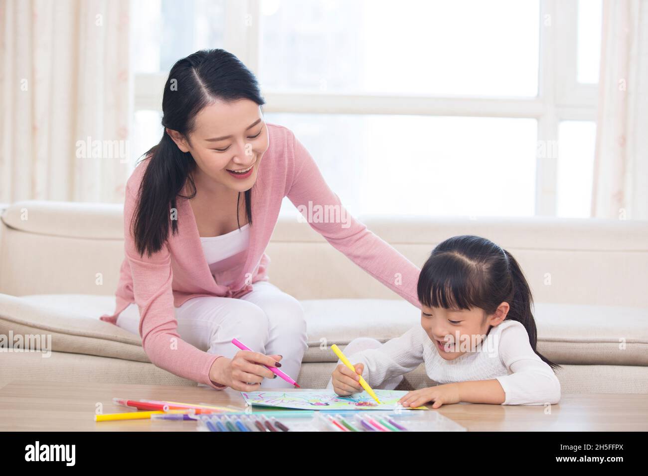 Mother and daughter drawing pictures together Stock Photo