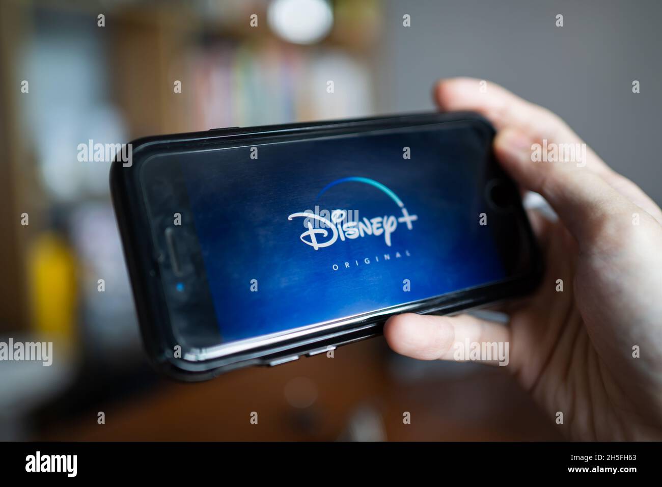 Bangkok, Thailand - November 9, 2021 :A mobile user using Disney+, a video streaming service app, on iPhone 7. Stock Photo
