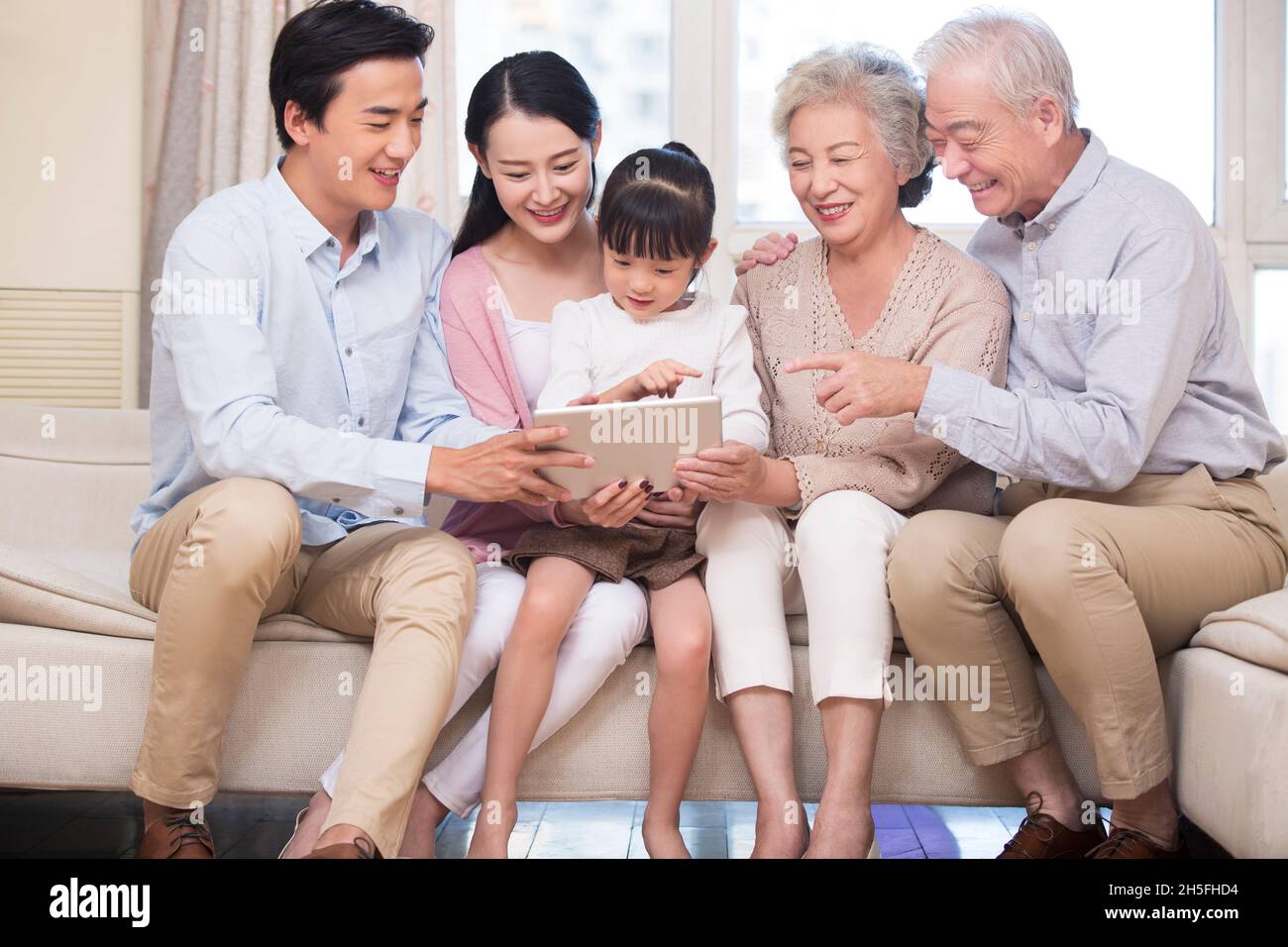 Happy families using a tablet computer together Stock Photo