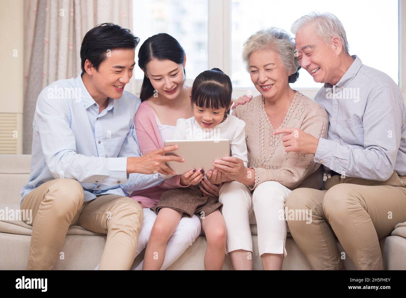 Happy families using a tablet computer together Stock Photo