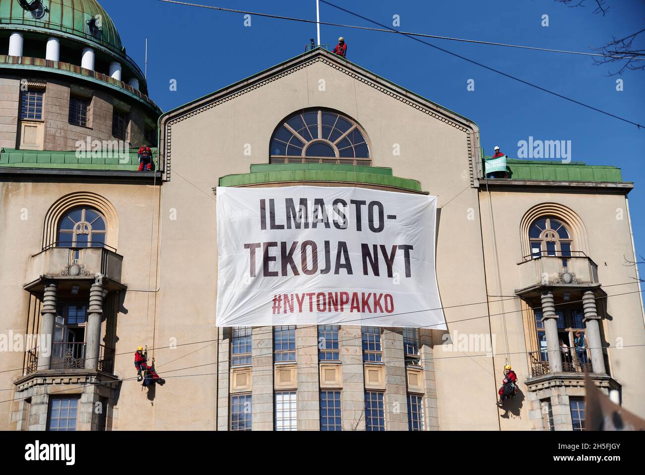 Helsinki, Finland - April 6, 2019: Greenpeace activists climb wall of the New Student House and place Climate action now (Ilmastotekoja nyt in Finnish Stock Photo