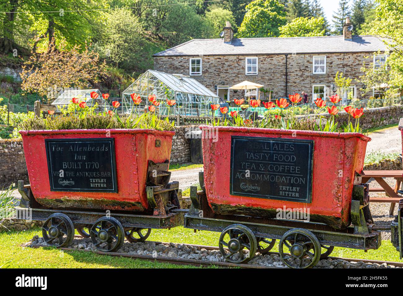 Old mine trucks and miners cottages in the former mining village of Allenheads in the Pennines to the north of Weardale, Northumberland UK Stock Photo