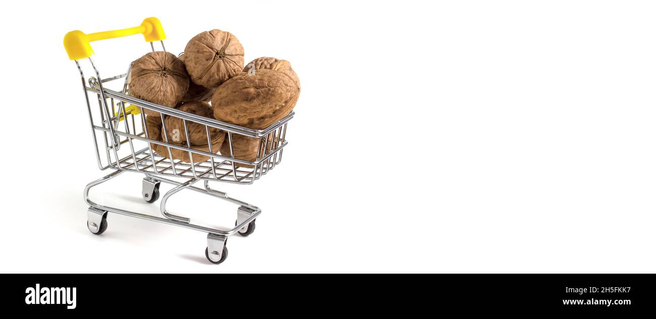 Shopping cart with walnuts isolated on white background with place for copy-space. Stock Photo