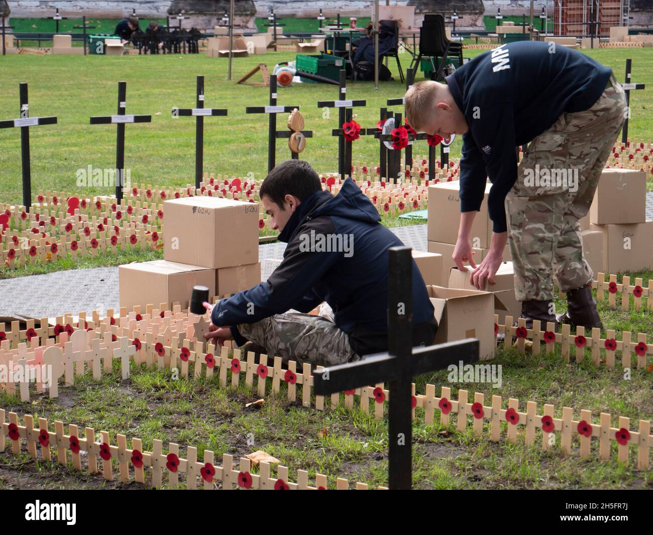 Volunteers plant crosses and poppies in Westminster Abbey Field of Remembrance, tributes carry personal messages Stock Photo