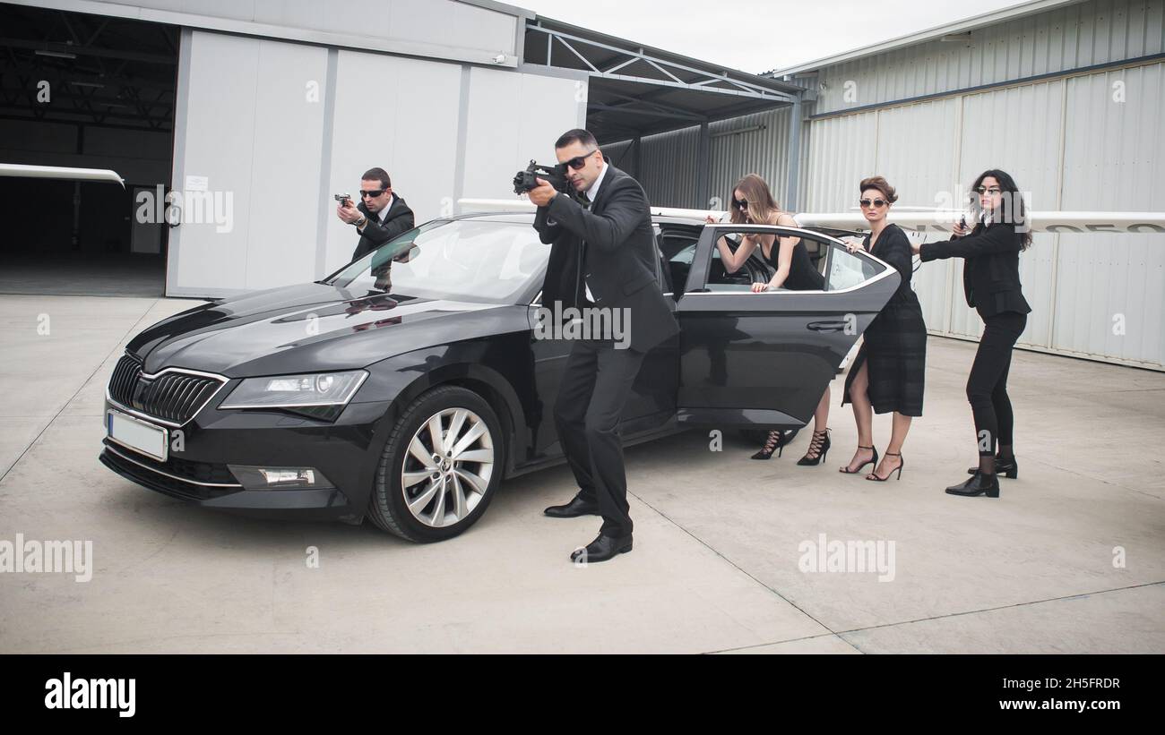 Professional Armed Team Of Female And Male Bodyguards Protect Celebrity Person In Car Limousine 