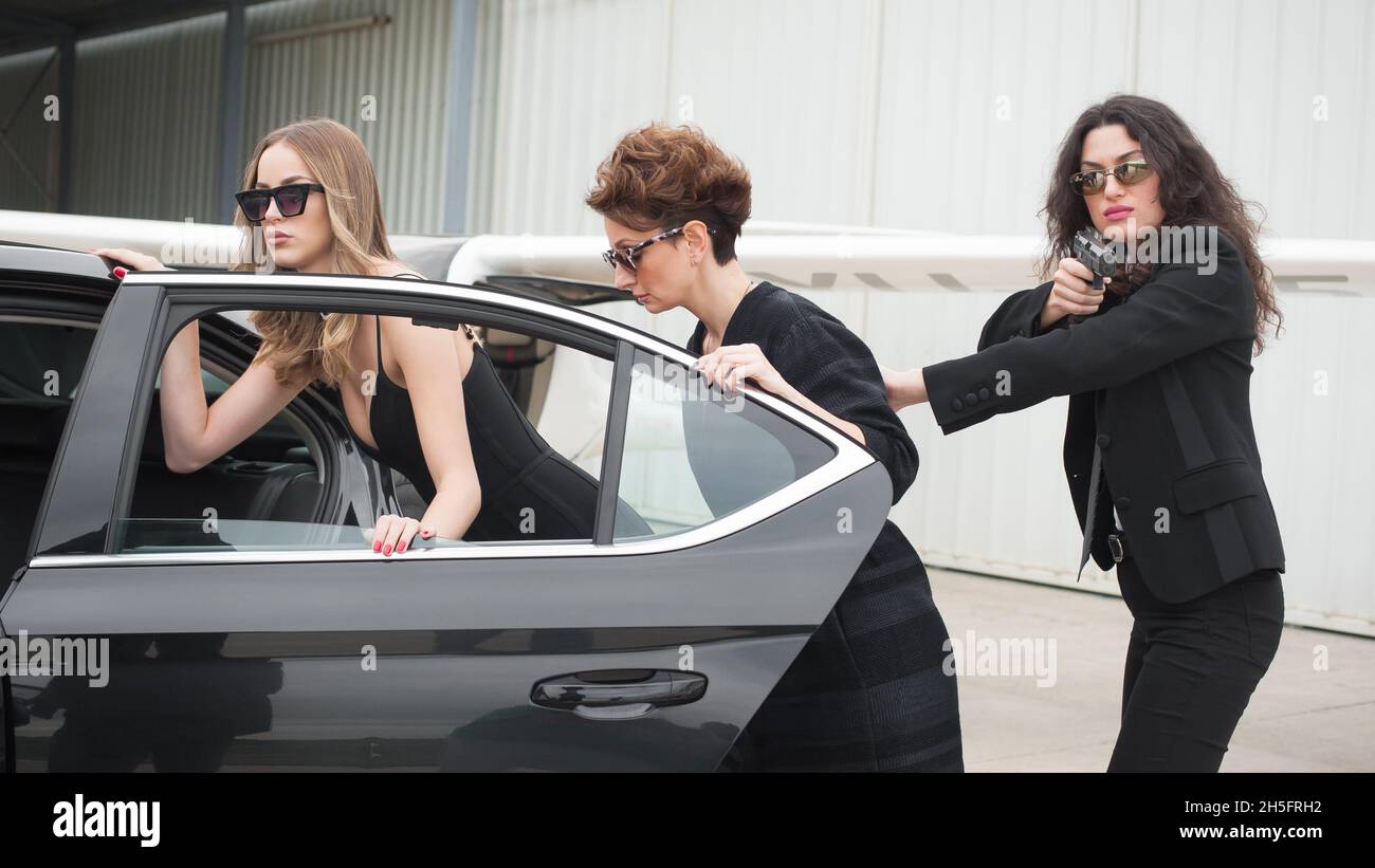 Professional armed team of female and male bodyguards protect celebrity