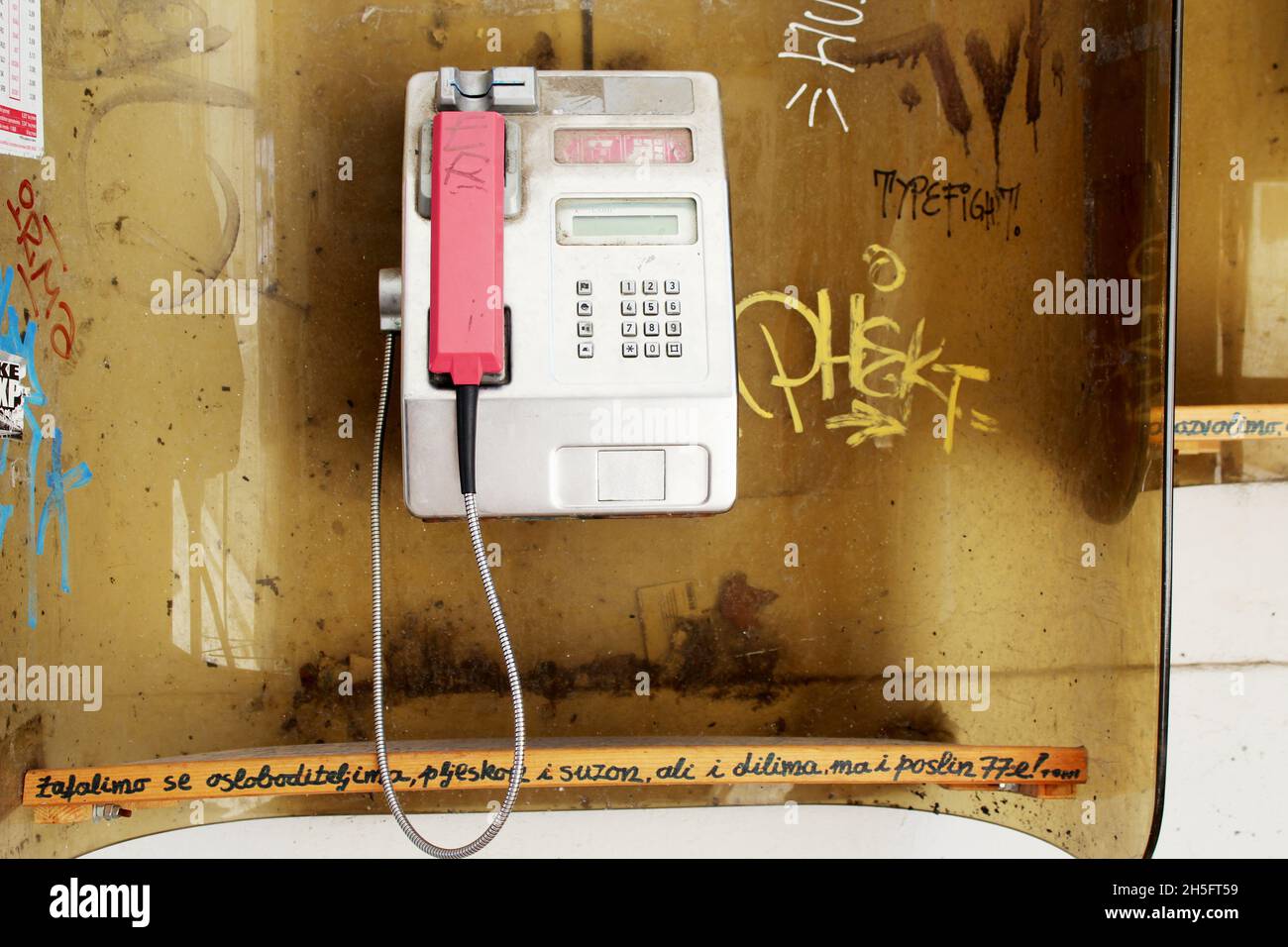 Öffentliche, offene Telefonzelle, die mit Graffiti verschmiert ist. Stock Photo