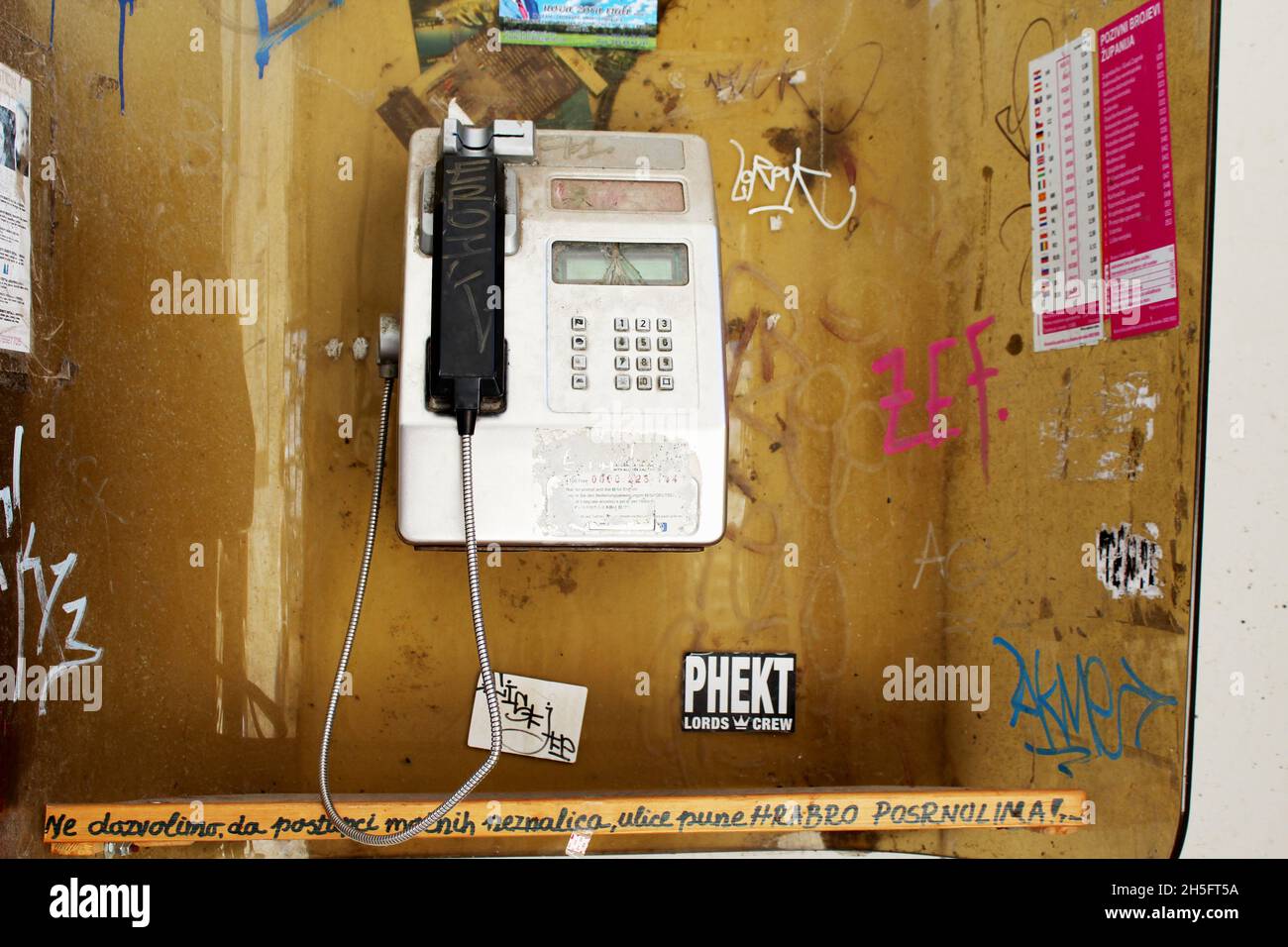 Öffentliche, offene Telefonzelle, die mit Graffiti verschmiert ist. Stock Photo