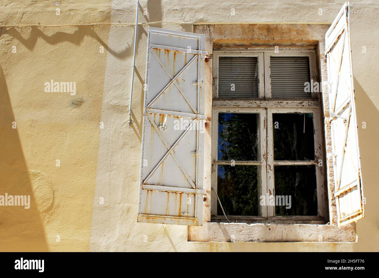Altes Fenster mit Fensterläden an einer alten Hausfassade in Kroatien. Stock Photo
