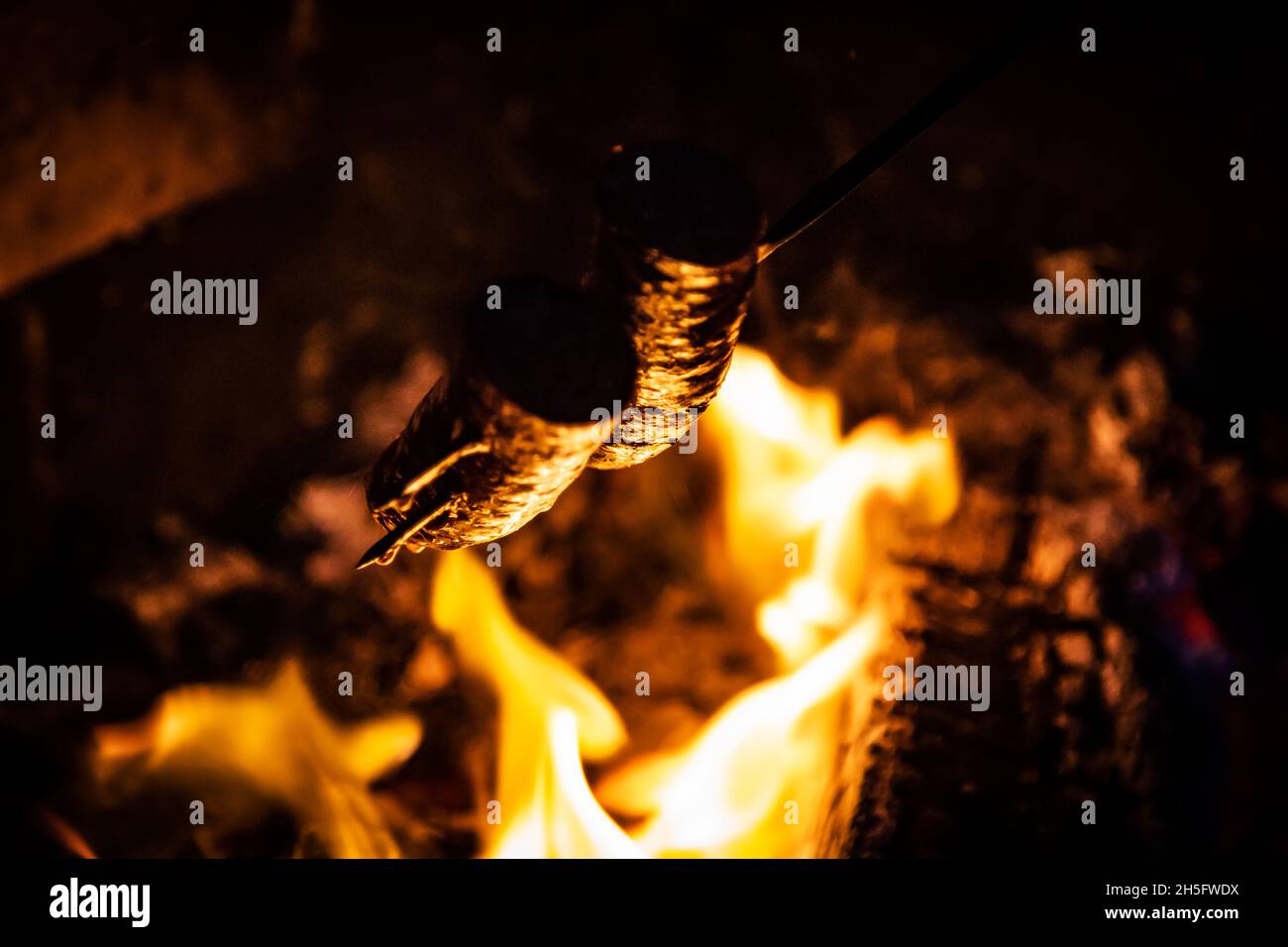 Sausage, food barbecue baking and cooking with fire flames and fat Stock Photo