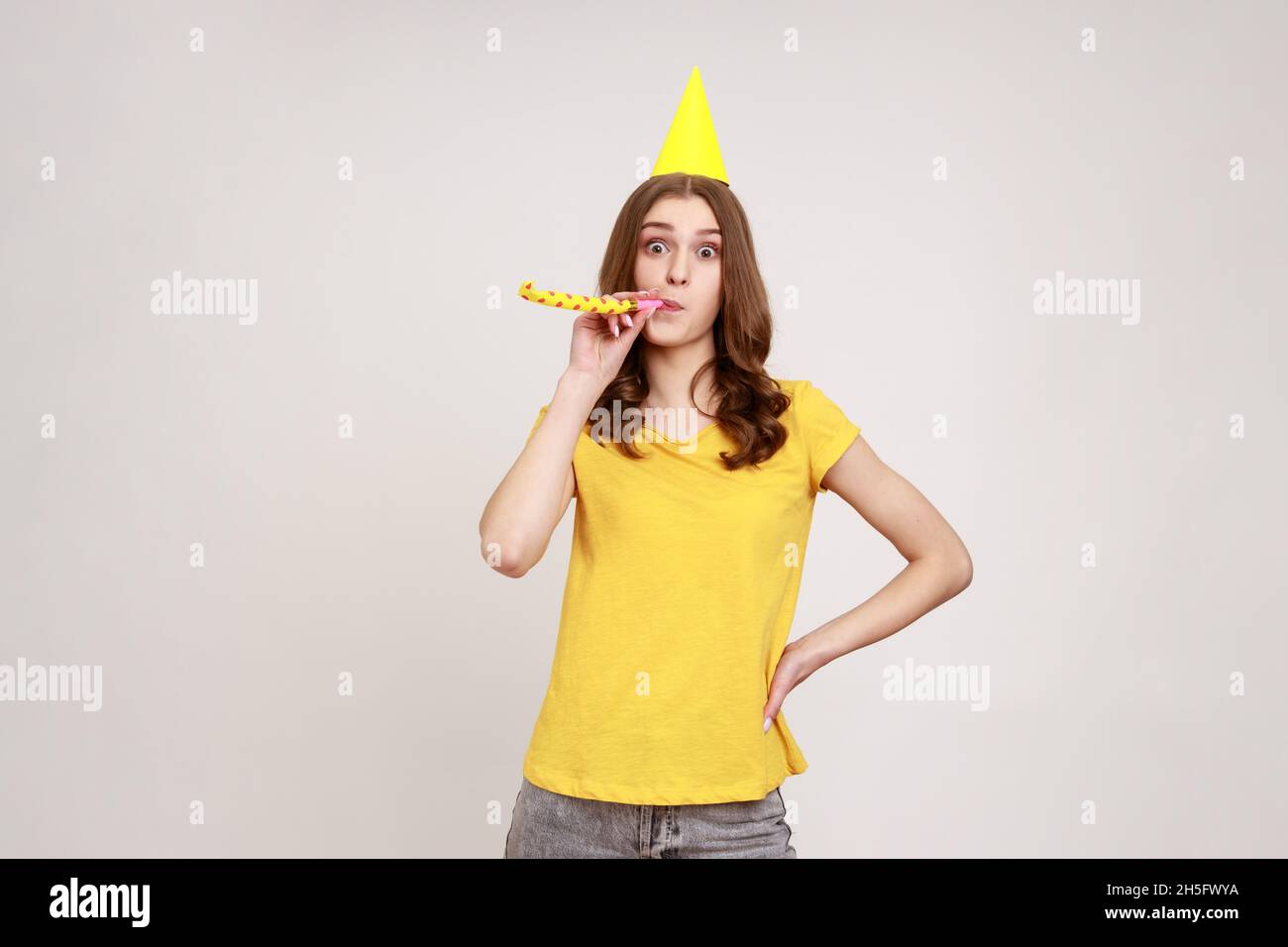 Portrait of happy adorable teenage girl in yellow T-shirt with birthday ...