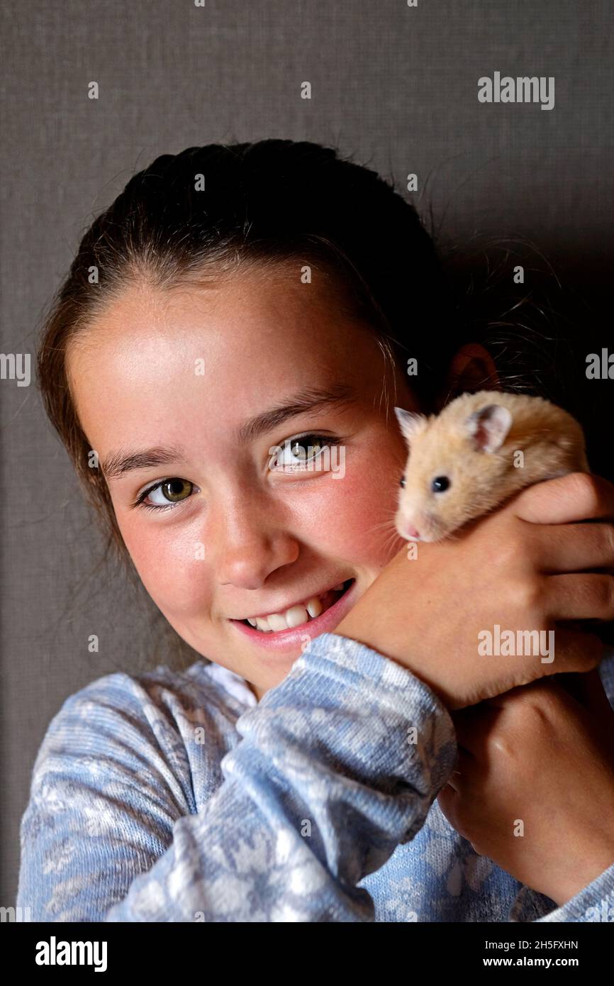 Young girl holding her pet hamster Stock Photo