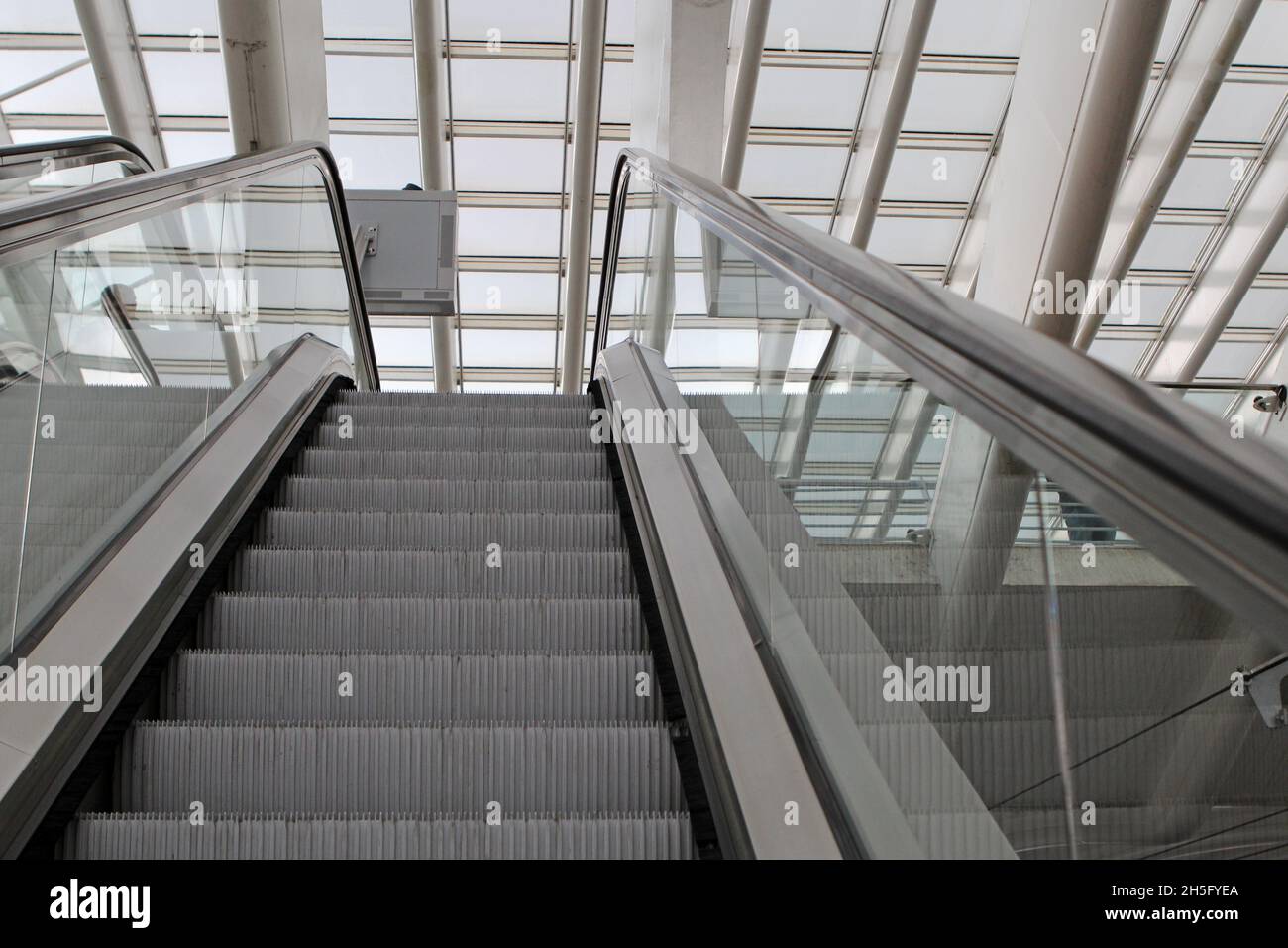 Leere Rolltreppe des Bahnhofs Bahnhof Liège-Guillemins, Lüttich, Belgien. Im Hintergrund die abstrakte, grafische Struktur mit Streben und Fenstern. Stock Photo