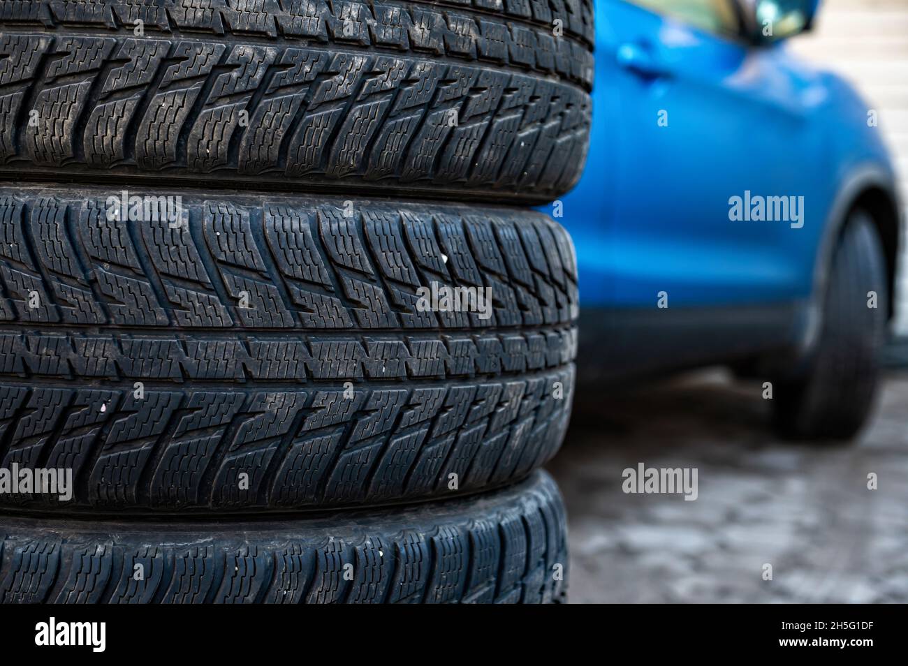 winter tires next to the car in wheel service, seasonal tire change