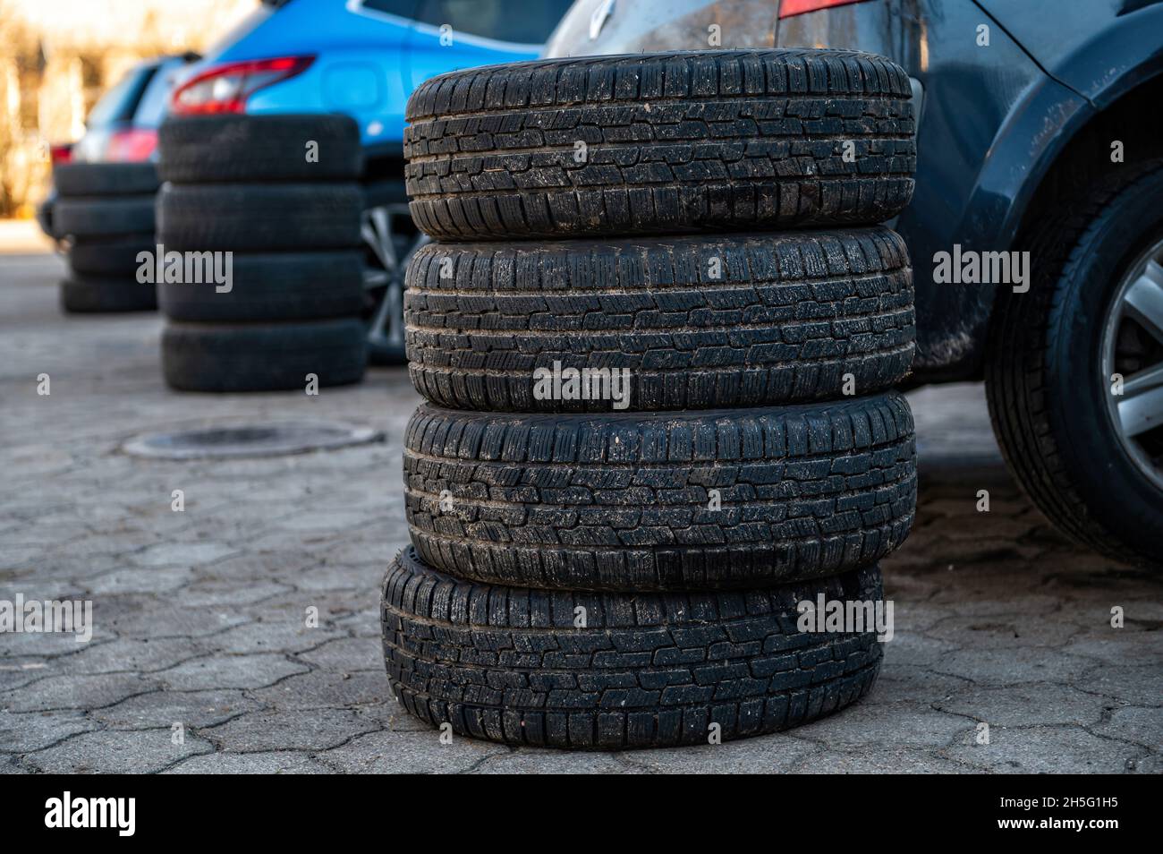 winter tires next to the car in wheel service, seasonal tire change