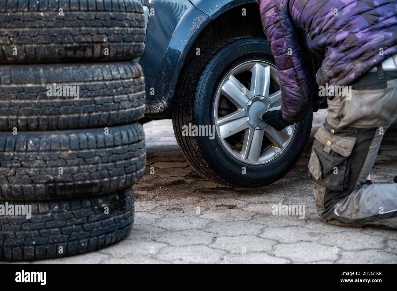 closeup view of man changing tire, seasonal tire change concept Stock