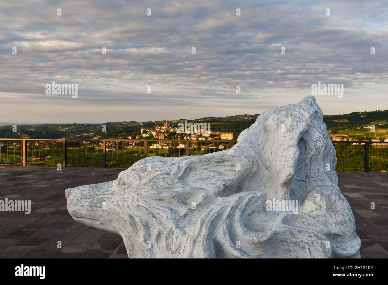 Statue representing a wolf on the panoramic terrace of Montelupo Albese with the Langhe hills and the town of Rodello in the background, Piedmont Stock Photo