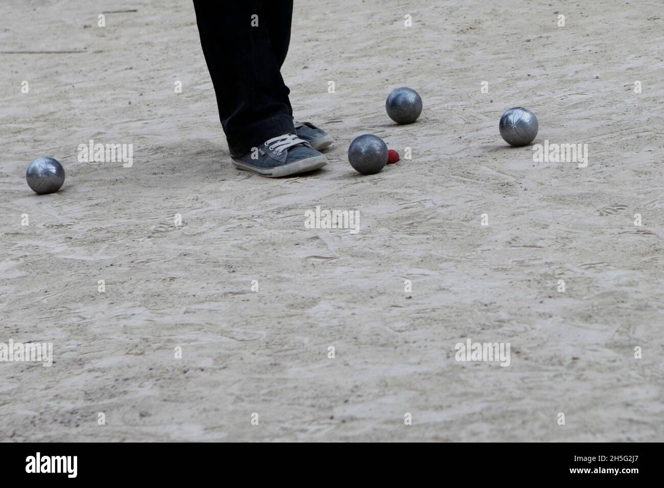 Ein Franzose, der gerade -auf einem öffentlichen Platz- Boule spielt. Keine Erkennbarkeit, da nur Bein. Cannes, Frankreich. Stock Photo