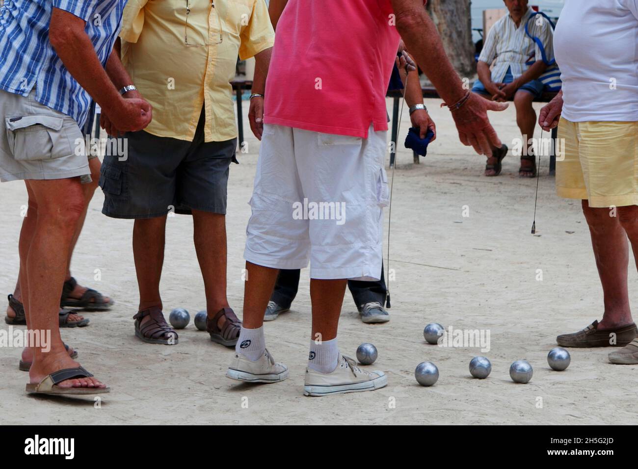 Franzosen, die gerade -auf einem öffentlichen Platz- Boule spielen. Keine Erkennbarkeit, da nur Beine. Cannes, Frankreich. Stock Photo