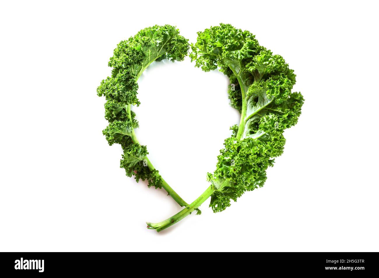 Winter vegetable kale or green leaf cabbage, two curly leaves in the shape of a heart, isolated on a white background, healthy eating concept, copy sp Stock Photo